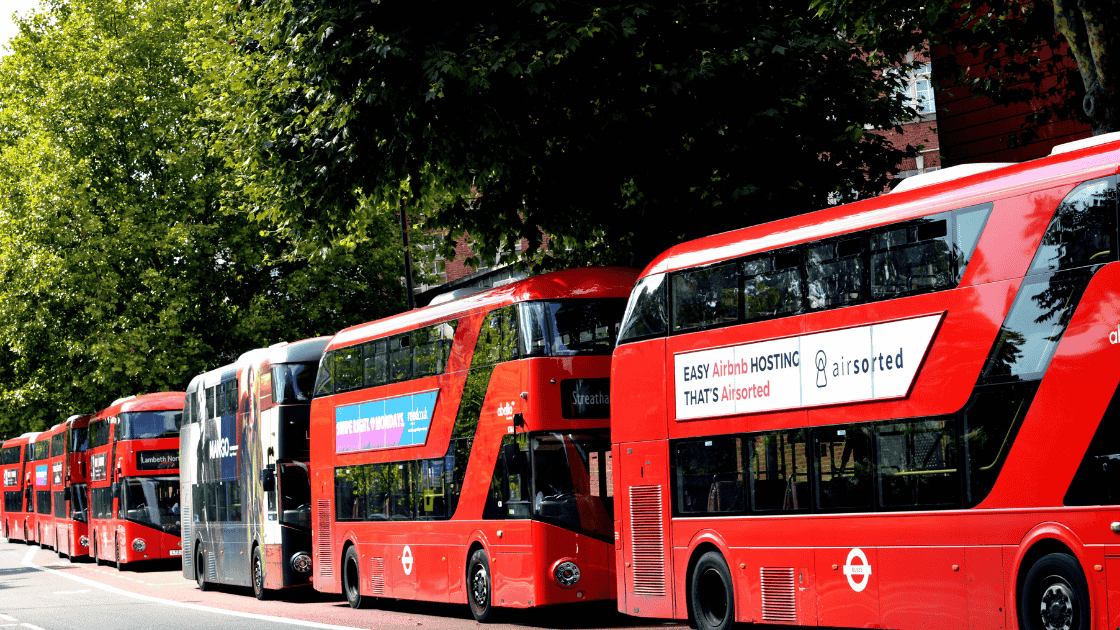 summer blog image 3 London red buses lined up on the road with adverts on their side.