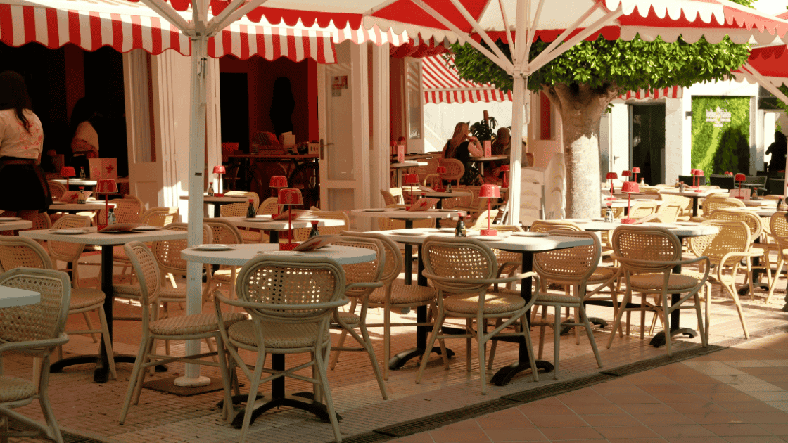 summer blog image 4 Sunny cafe with tables and chairs and a red and white striped awning
