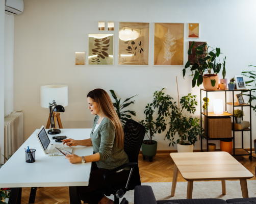 13 A lady working at home looking at her laptop on her desk
